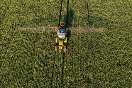 aerial view of harvest fields with tractor in Polandの写真素材