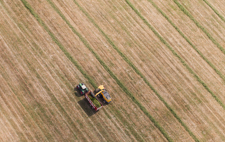 aerial view of harvest field with tractor and combine in Polandの写真素材