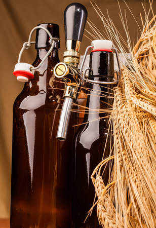 bottle of light beer and spikes of barley on tableの写真素材