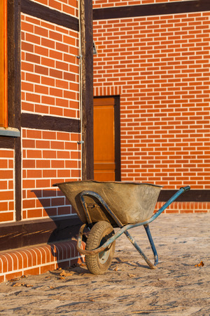 used wheelbarrow and  renovated  old buildnigの写真素材