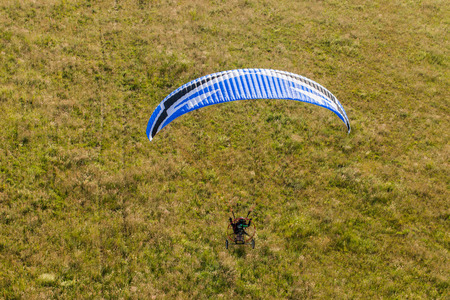 aerial view of paramotor flying over the fields in summer