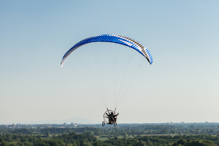 aerial view of paramotor flying over the fields in summer