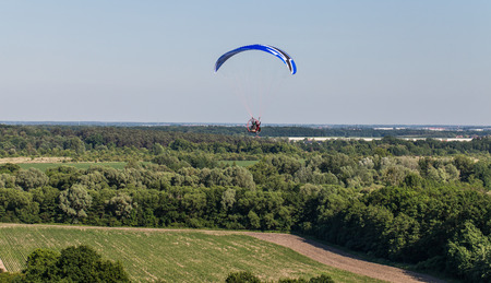 aerial view of paramotor flying over the fields in summerの写真素材