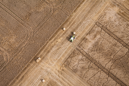 aerial view of harvest fields with tractor in Poland in summerの写真素材