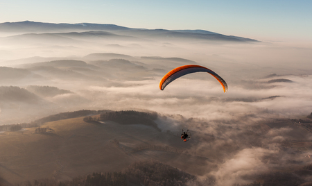 aerial view of paramotor flying over the clouds in Polandの写真素材