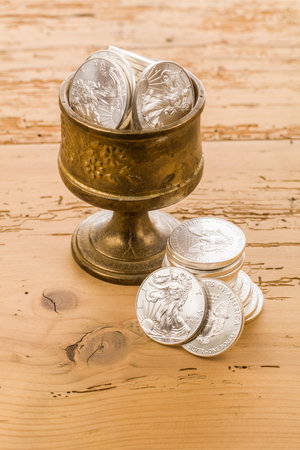 Ancient silver coins on a wooden table. Vintage style toned pictureの写真素材