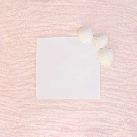 sandy flat lay copy space with pastel pink beige background and white space in the middle.sunny day summer concept with sea shellsの写真素材