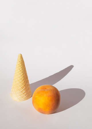 orange peach and ice cream cone on a white background with soft shadows.sunny day idea.fresh food designの写真素材