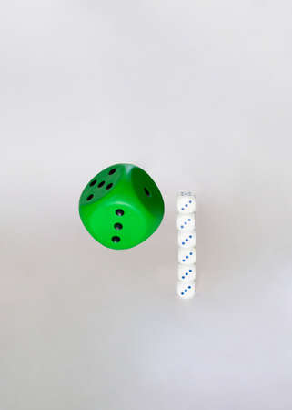 green dice flying next to white small ones.concept idea design on a white backgroundの写真素材