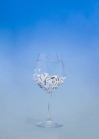 dices in a wine glass on a sky blue  background.minimal still life abstract design conceptの写真素材