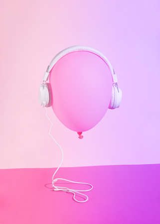 balloon pink with headphones.pink background.balloon head listening to the music.concept design idea.vibrant 80s colorsの写真素材