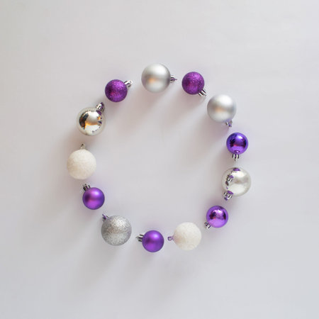 circle made of vivid violet, metallic silver and snowy white baubles.copy space aesthetic Christmas...