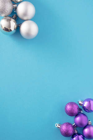 vivid blue and metallic silver baubles in opposite angles on a blue background.Christmas shiny objects for preparation of holidaysの写真素材