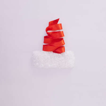 Christmas tree made of satin strap.Santa Claus hat.Holidays design.White and red New Year concept ideaの写真素材