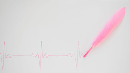 EKG line written with soft pink feather. Flat lay aesthetic.Health, life, love design concept idea