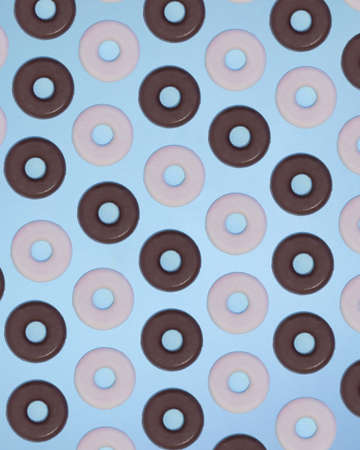 Chocolate round cookies making pattern on a soft blue sky background. Food aesthetic sweets concept. Flat lay designの写真素材