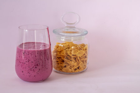smoothies of berries and cornflakes on a pink background