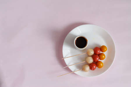 japanese dango treat on white plate and pink backgroundの写真素材