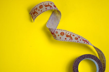 a red notepad lies on a yellow background, a metal toy with the inscription merry christmas lies on...