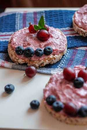 homemade cake with pink berry cream and fresh blueberries on cornbread,