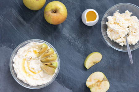 cottage cheese poured with syrup with slices of fresh pear, dark background, top viewの写真素材