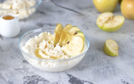 cottage cheese poured with syrup with slices of fresh pear, dark background, top viewの写真素材