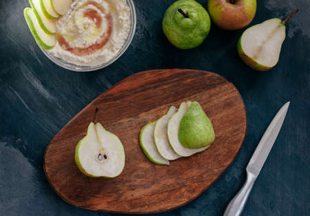 cottage cheese poured with syrup with slices of fresh pear, dark background, top viewの写真素材