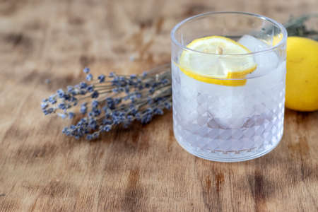 lavender lemonade with ice in a low glass glass stands on a tableの写真素材
