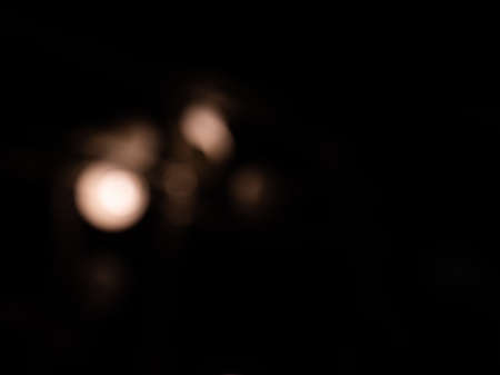 bokeh warm white light on black background overlayの写真素材