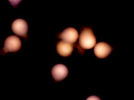 bokeh calming peach light on black background overlayの写真素材