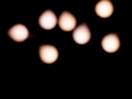 bokeh warm white light on black background overlayの写真素材