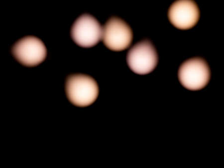bokeh warm white light on black background overlayの写真素材