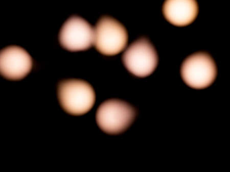 bokeh warm white light on black background overlayの写真素材