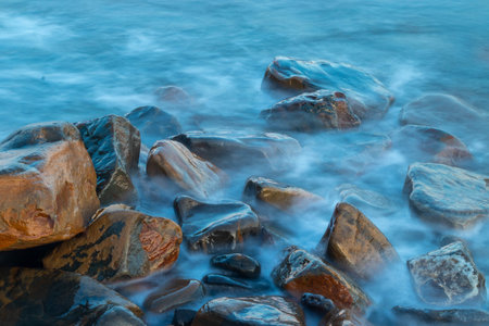 Stones in sea water. Waves on long exposureの写真素材