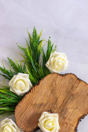 Background. A wooden saw, green grass and white roses lie on a marble grey background.の写真素材