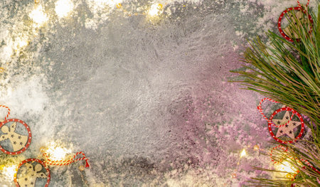 New Years eve. On a gray background lie artificial snow, a yellow garland and wooden toys.の写真素材