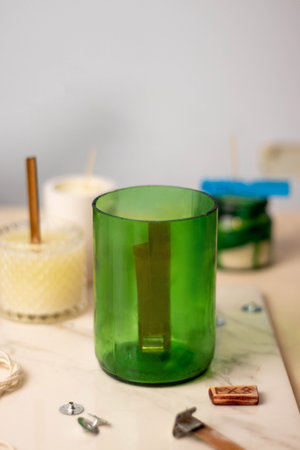 A green glass from a wine bottle for a candle. wooden wickの写真素材