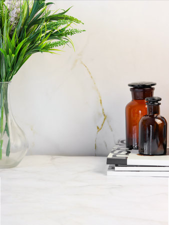 Brown glass bottles stand on a marble background, in a vase a bouquet of greenery. Background. Copyspaceの写真素材