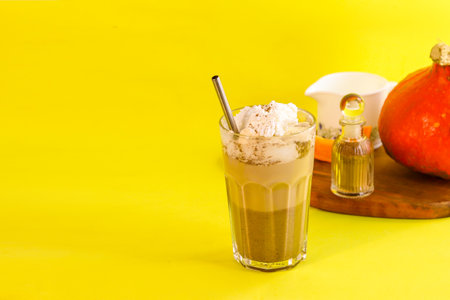 coffee with cream in a glass glass on a yellow backgroundの写真素材