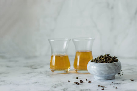 Leaf tea in a marble bowl and two glass Turkish cups with tea