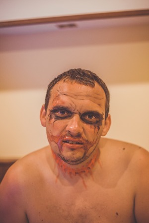 Man preparing before  Halloween dressed as a jokerの写真素材