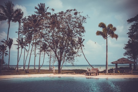 Pond, boat and sea among palm treesの写真素材