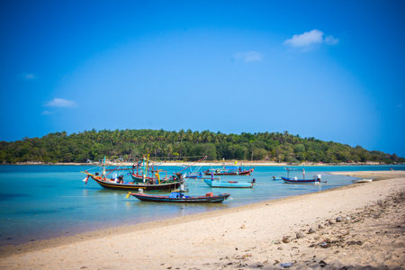 Boats on sand beach overlooking islandの写真素材