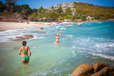 beautiful young woman wearing a green bikini playing at the beach with her friend on Koh Samui. Thailandの写真素材