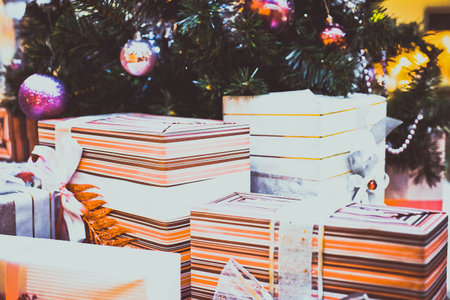 Close up of Decorated Christmas tree and boxes of gifts with bows