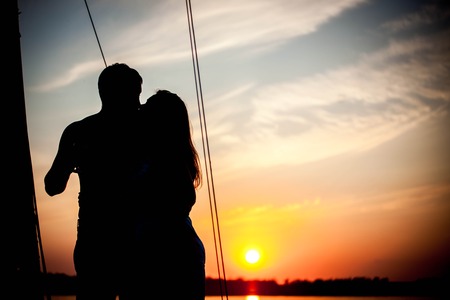 romantic couple in love on a pleasure yacht relaxing at sunset timeの写真素材