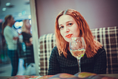 A smiling woman in a restaurant with the menu in handsの写真素材