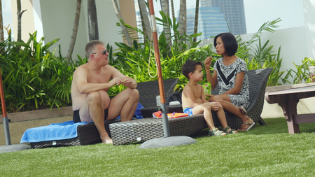 Thailand, Bangkok, 25 november 2015. Family from the European farang with an Asian woman vacation relaxing by the hotel outdoor swimming pool.のeditorial素材