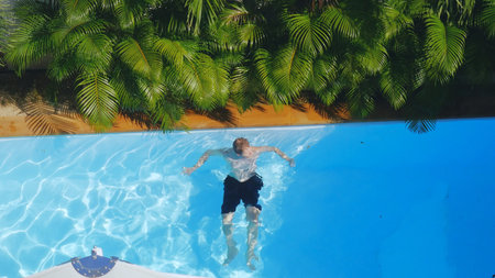 Top of view of man swimming in outdoor pool