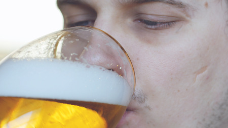 Handsome man drinking beer in cafeの写真素材